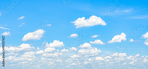 the sky is clear blue with fluffy white clouds, the sky is very bright, and the sun shines.