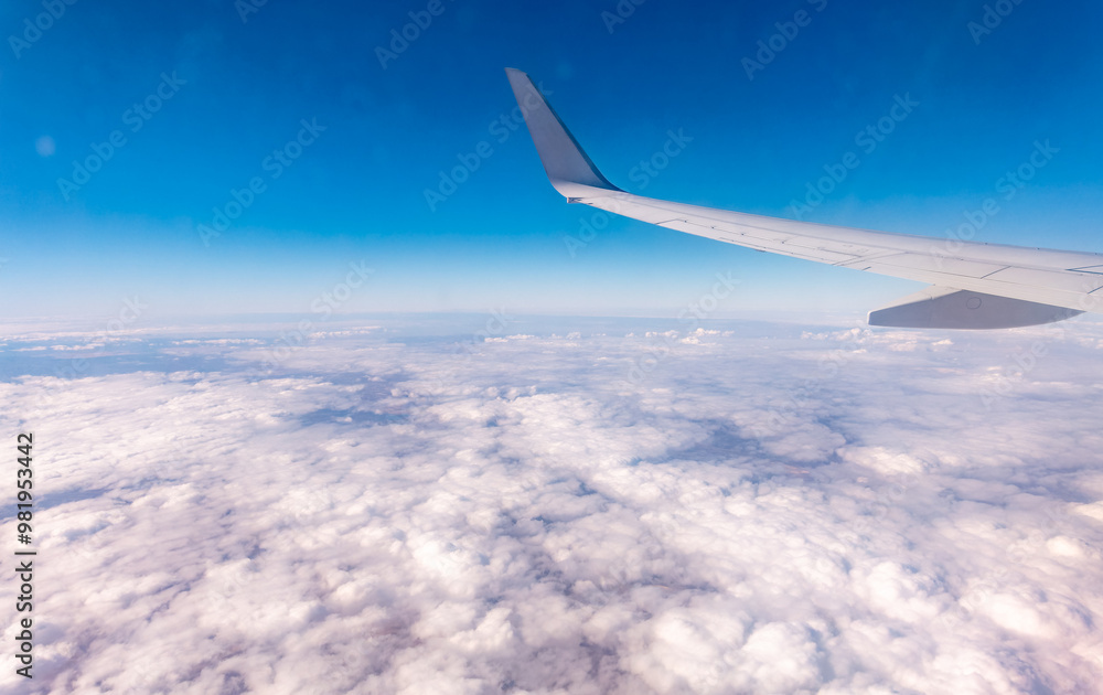 View from the airplane window at a beautiful cloudy sky and the airplane wing View from the airplane window at a beautiful cloudy sky and the airplane wing