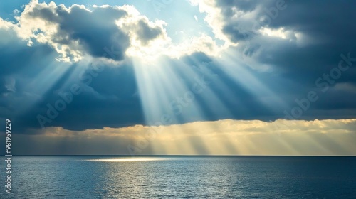 Rayos de sol atravesando las nubes sobre el océano durante el Día de Todos los Santos. La luz celestial que ilumina el agua transmite paz y una conexión con la espiritualidad.