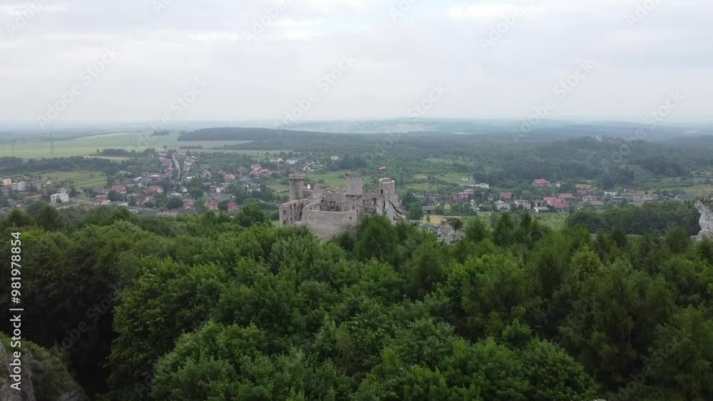 Flying from the forest over the ruins of medieval castle in Ogrodzieniec Poland (the one from Witcher movie) Flying from the forest over the ruins of medieval castle in Ogrodzieniec Poland (the one from Witcher movie)