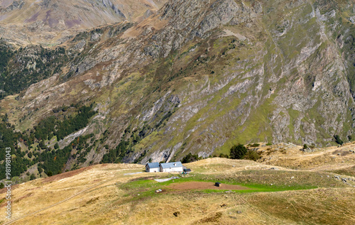 A small house sits on a hillside with a view of the mountains photo