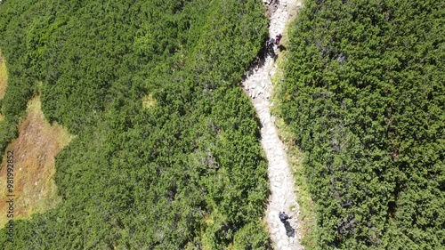 Drone flight over tourists walking the path  and final look at Giewont, Tatry mountains, Poland, summertime