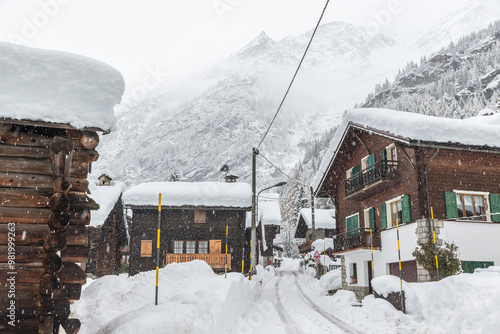 Bad weather and heavy snow in the mountains. Mountain village in winter. Snowy road between the huts and houses of Macugnaga, Italy, important ski resort at the foot of Monte Rosa, europeans Alps