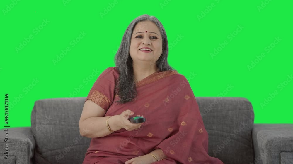Cheerful Indian old woman watching TV Green screen Cheerful Indian old woman watching TV Green screen