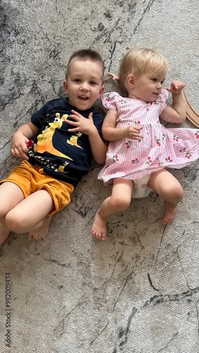 Little brother and sister lying on the floor