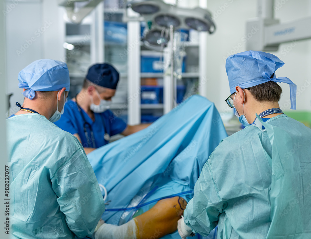 Surgeons operate on a patient. A surgical team focuses on a procedure as they operate on a patient in a well-equipped hospital operating room. Surgeons operate on a patient. A surgical team focuses on a procedure as they operate on a patient in a well-equipped hospital operating room.