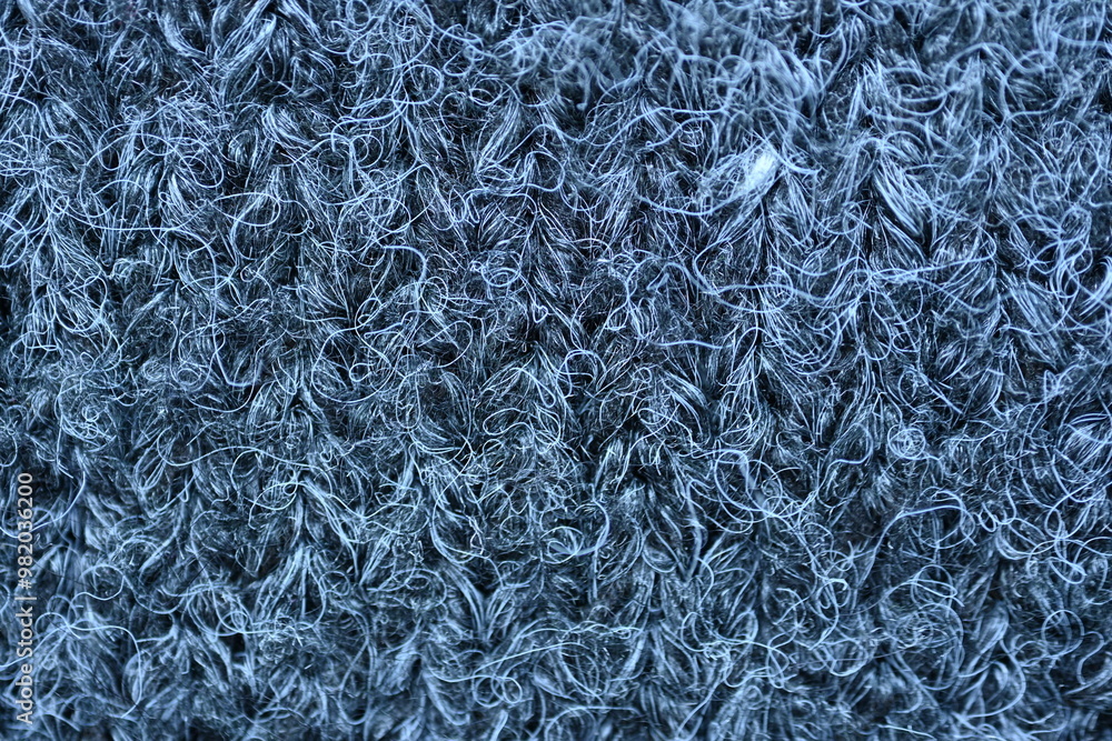 macro texture of woolen dark gray crocheted sweater as background, close-up of gray crocheted front surface, woolen texture of woolen wool, knitted front surface macro texture of woolen dark gray crocheted sweater as background, close-up of gray crocheted front surface, woolen texture of woolen wool, knitted front surface