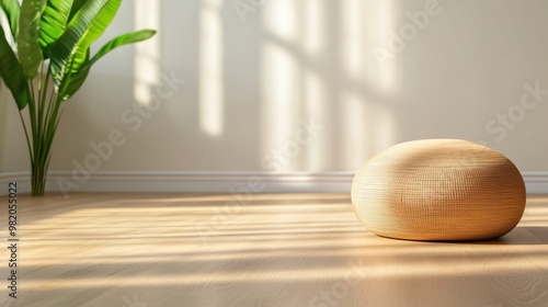 A small round object sitting on a hardwood floor next to a plant, AI