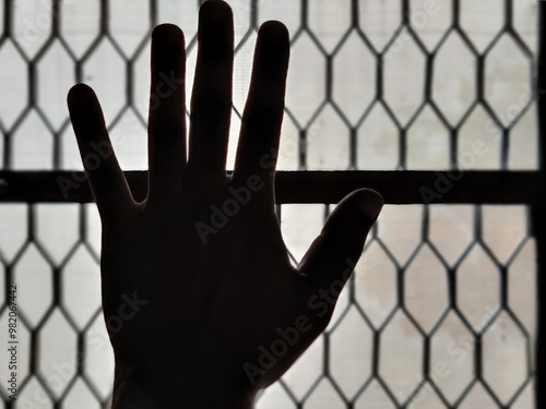 Silhouette of a man's hand stretching out against sunlight for hope
 photo