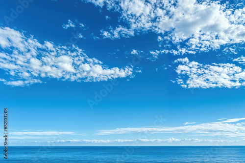 White clouds on deep blue sky over a calm ocean