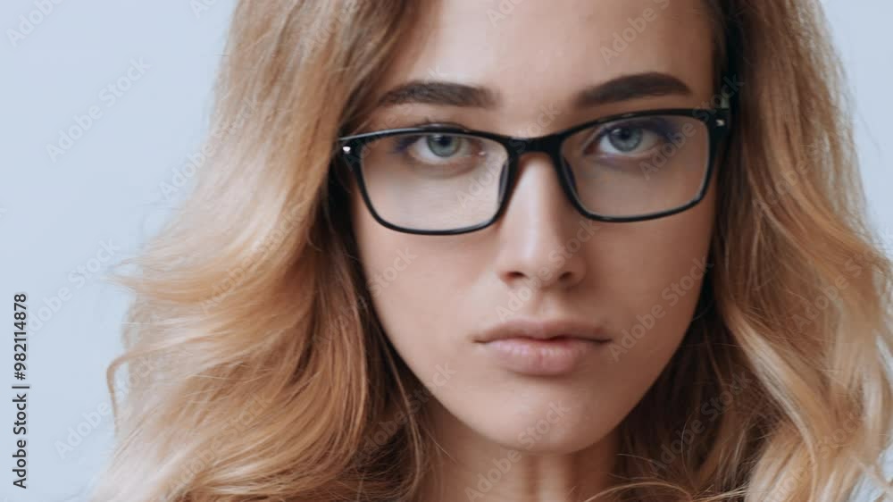 A young woman with wavy blonde hair and glasses closes her eyes while taking a moment of reflection in a serene atmosphere, exuding tranquility and contemplation. A young woman with wavy blonde hair and glasses closes her eyes while taking a moment of reflection in a serene atmosphere, exuding tranquility and contemplation.