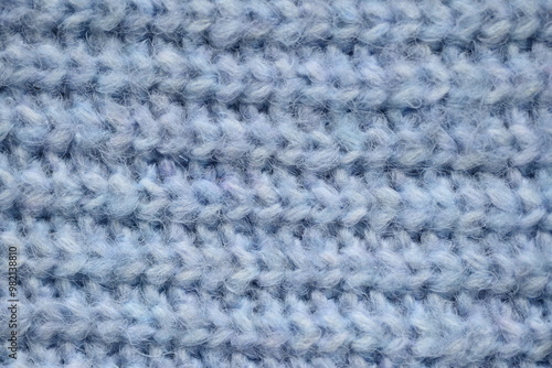 macro texture of woolen blue crocheted sweater as background, close-up of blue crocheted front surface, woolen texture of woolen wool, knitted front surface