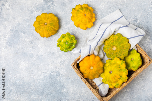 Pattypan zucchini on a textured kitchen table. squash. Fresh organic pattypan squashes on background. Vegan. Farmer's Market. Patisson. Space for text. Copy space. photo