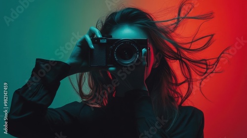 A woman is holding a camera and looking through the viewfinder