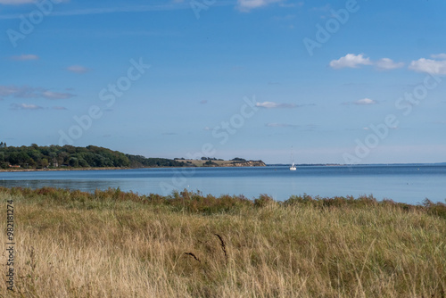 A boat is sailing in the ocean near a shore