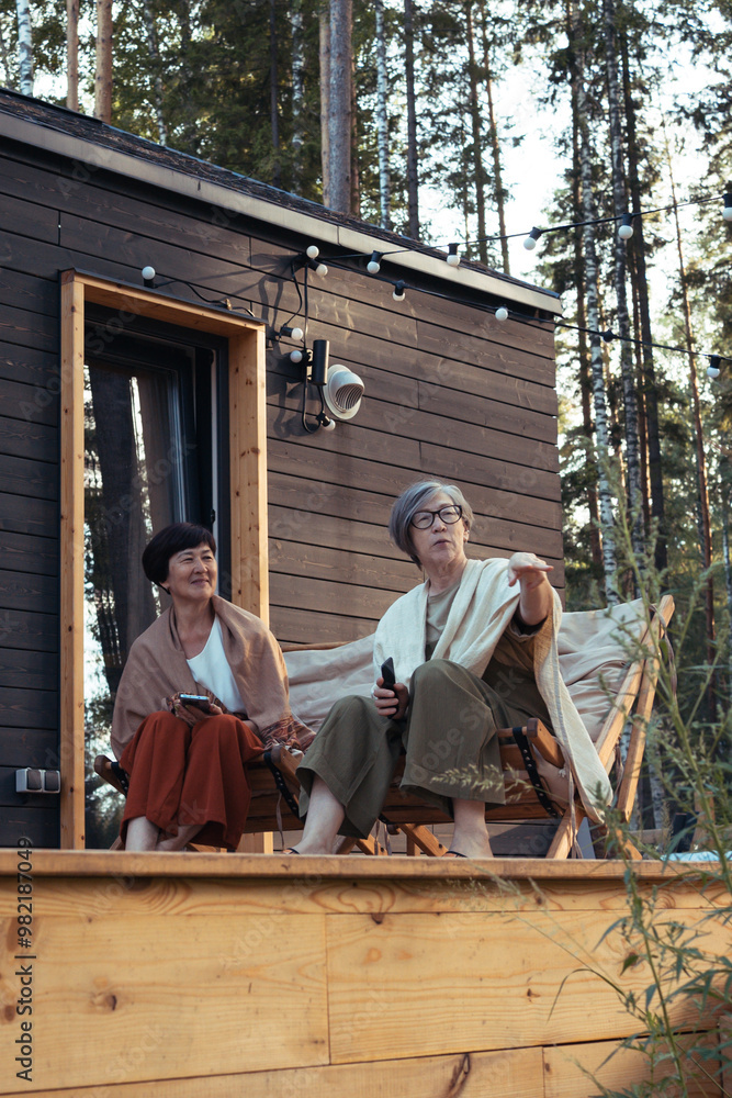 Two asian senior women sitting on terrace and having fun together Two asian senior women sitting on terrace and having fun together