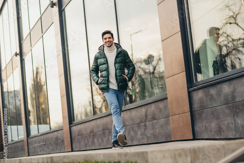 Photo of positive cheerful handsome man walking city center spring day outdoors photo