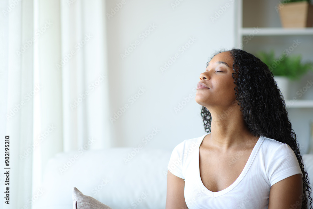 Black woman relaxing breathing fresh air on a sofa Black woman relaxing breathing fresh air on a sofa