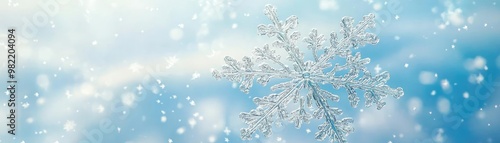 A delicate snowflake captured against a soft blue background, embodying the beauty and serenity of winter.