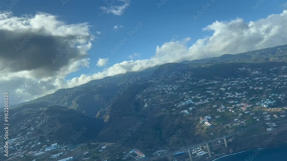 Aerial panoramic view of the south coast of Madeira island as seen by the pilots of an airplane approaching to Funchal airport. Late in the afternoon light. Blue sky with some clouds. 4K 60FPS Aerial panoramic view of the south coast of Madeira island as seen by the pilots of an airplane approaching to Funchal airport. Late in the afternoon light. Blue sky with some clouds. 4K 60FPS