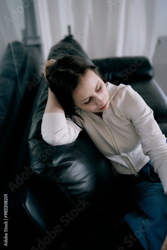 young teenage girl fighting brain cancer at photo shoot in studio, metal wall, reflection, black sofa