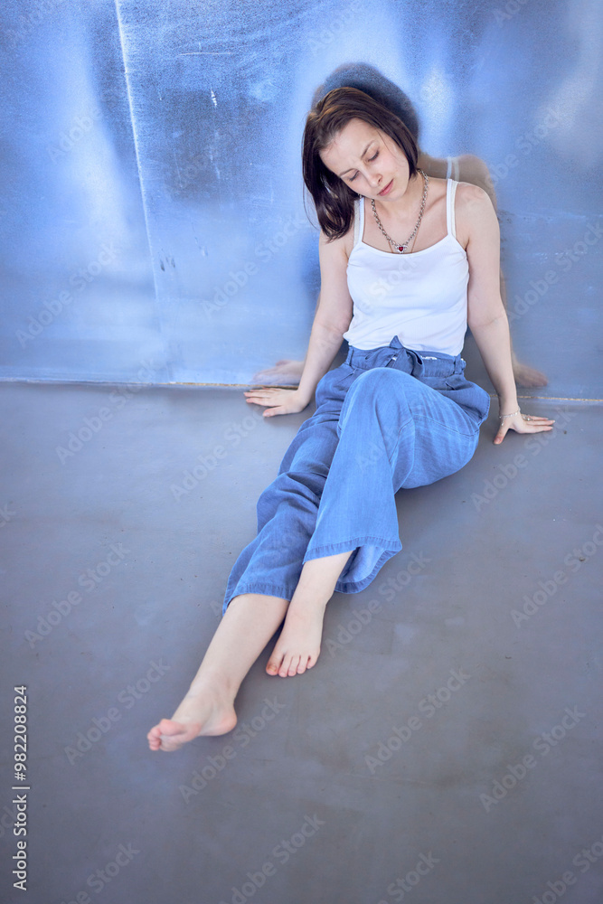 young teenage girl fighting brain cancer at photo shoot in studio sitting on floor, leaning against metal wall, reflection young teenage girl fighting brain cancer at photo shoot in studio sitting on floor, leaning against metal wall, reflection