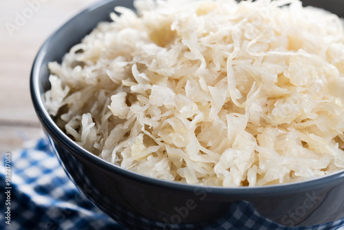 Sauerkraut in a bowl on wooden table. Traditional german food. Close up