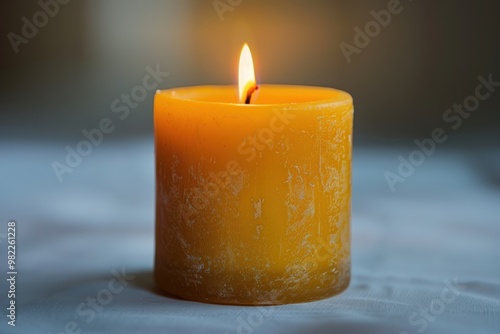 Single Pillar Candle Burning on Marble Surface in Sunlit Room 