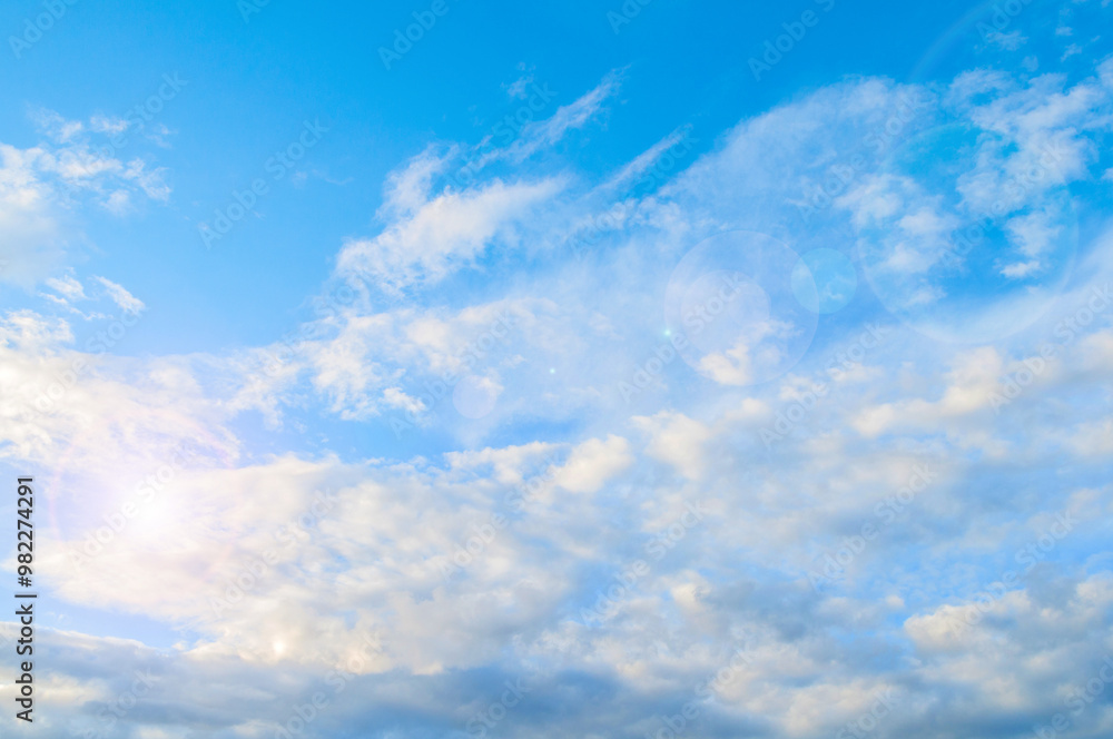 Morning blue sky background. White dramatic fluffy clouds lit by morning light. Vast morning blue sky scene Morning blue sky background. White dramatic fluffy clouds lit by morning light. Vast morning blue sky scene