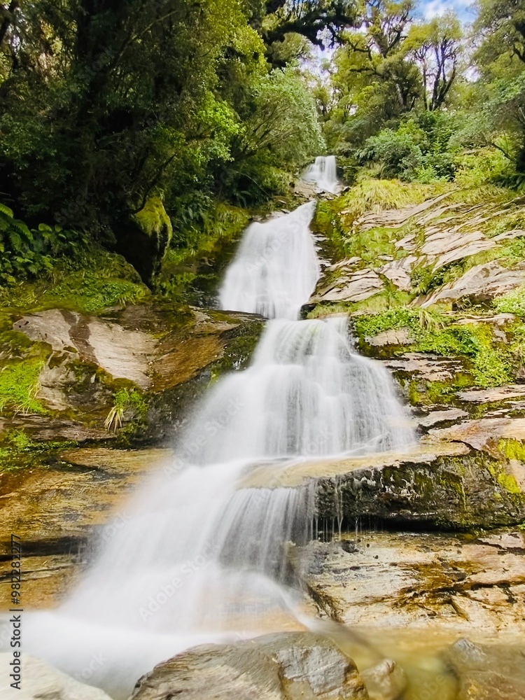 Obraz premium Long exposure image of Depot Creek Falls in Haast, South Island, New Zealand. Waterfall in the forest