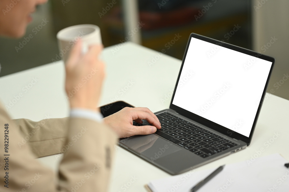 Professional businessman drinking hot coffee and using laptop on office desk Professional businessman drinking hot coffee and using laptop on office desk