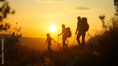 A family, a father and two sons, hiking in the wilderness at sunset.