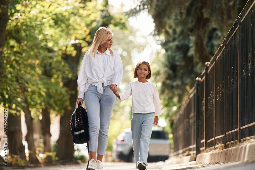 Obraz premium Leading the daughter to school. Little girl with her mother are outdoors together