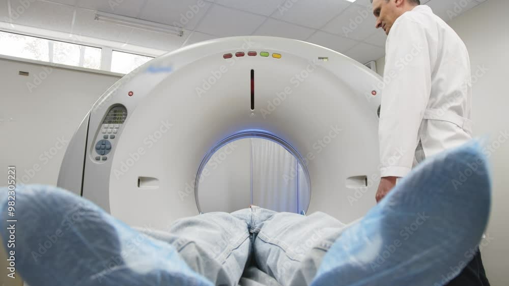 In a bright diagnostic center, a young man undergoes a CT or MRI scan using modern equipment. This image reflects the forefront of medical technology, emphasizing precision and patient care. In a bright diagnostic center, a young man undergoes a CT or MRI scan using modern equipment. This image reflects the forefront of medical technology, emphasizing precision and patient care.