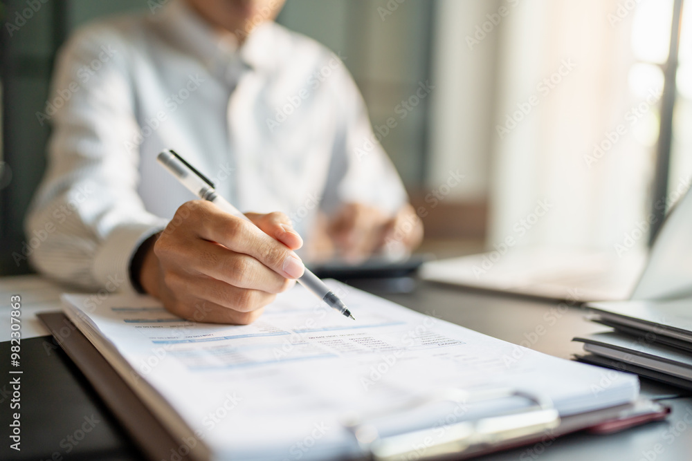 Close up of businessman hands signing or writing document paperwork and report Auditor analysis male professional hand making notes with Business Document. Close up of businessman hands signing or writing document paperwork and report Auditor analysis male professional hand making notes with Business Document.