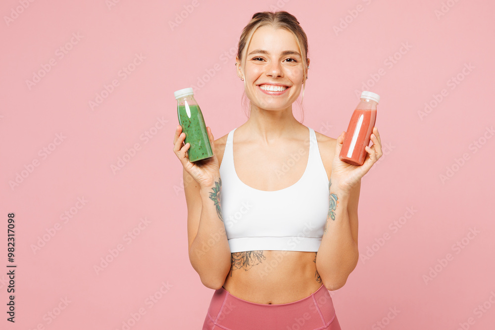 Young happy woman wears white top casual clothes hold orange green juice smoothie as detox isolated on plain pastel light pink background. Proper nutrition healthy fast food unhealthy choice concept. Young happy woman wears white top casual clothes hold orange green juice smoothie as detox isolated on plain pastel light pink background. Proper nutrition healthy fast food unhealthy choice concept.