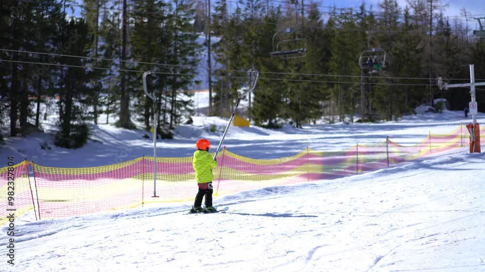 Little boy lifting on the ski drag lift rope, slow motion Little boy lifting on the ski drag lift rope, slow motion