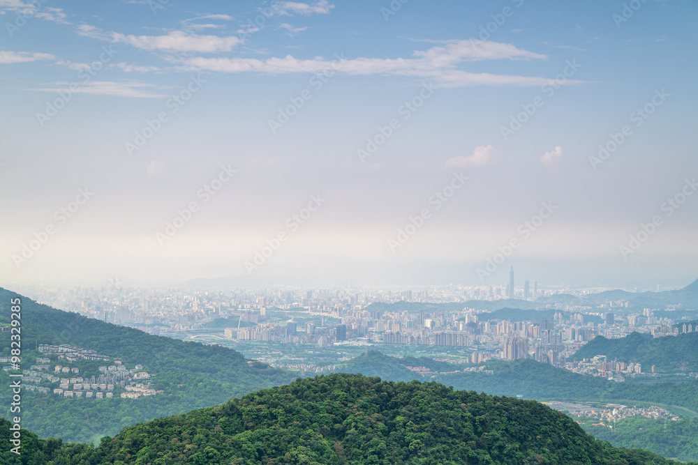 Obraz premium A panoramic view of Taipei City from Shizitou Mountain. The cityscape is shrouded in a soft haze, creating a dreamlike atmosphere.