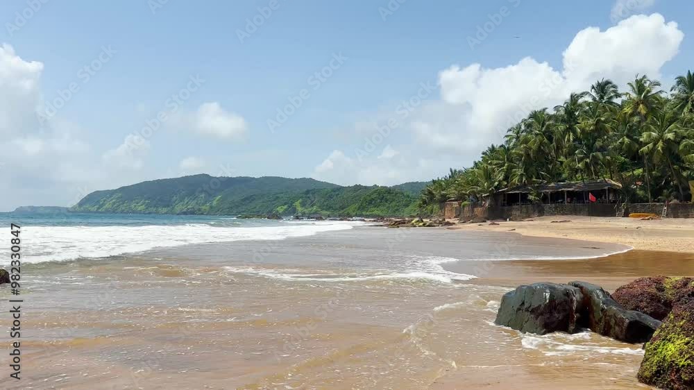 4K Wide angle shot of sea waves on the shore of a tropical beach ih Goa, India. Sea waves on the shore of a tropical beach island. Sea waves at the beach on a remote island. 4K Wide angle shot of sea waves on the shore of a tropical beach ih Goa, India. Sea waves on the shore of a tropical beach island. Sea waves at the beach on a remote island.
