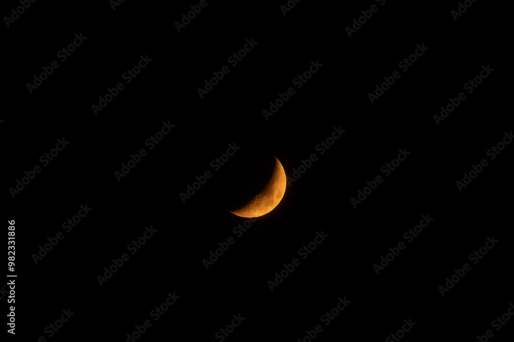 A high-resolution image of an yellow crescent moon against a dark sky. The moon is crisp and detailed, making it perfect for compositing. A high-resolution image of an yellow crescent moon against a dark sky. The moon is crisp and detailed, making it perfect for compositing.