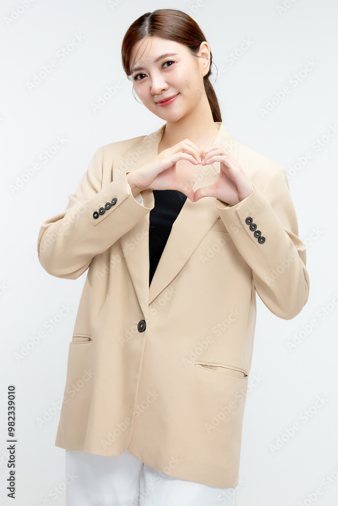 Young beauty Asian business woman making heart shape hand sign isolated on white background. Young beauty Asian business woman making heart shape hand sign isolated on white background.