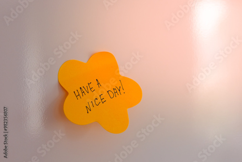 Bright yellow sticky note with a cheerful message on a wall for an uplifting start to the day photo