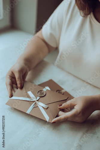 Female Hands Holding Holiday Gift Voucher on table