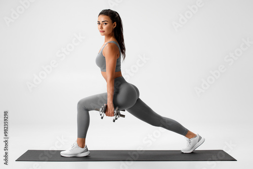 Active girl doing lunges exercises for leg muscle training. Fitness woman doing front forward one leg step lunge exercise