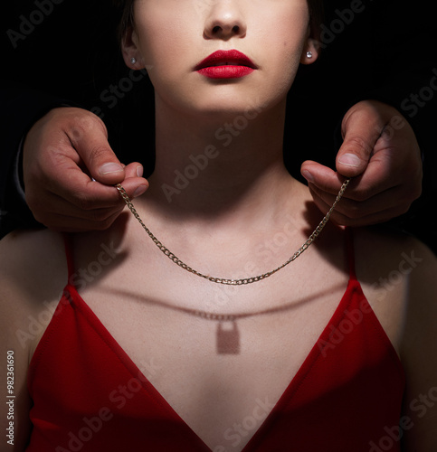 Necklace, lock and gift with couple in studio for toxic relationship, abuse and secret. Jewelry, fear and possessive with people on black background for control, gaslighting and intimidation photo