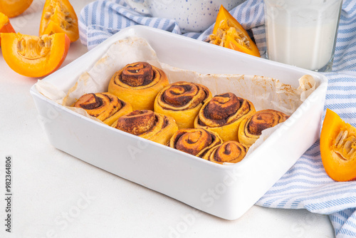 Homemade sweet autumn pumpkin cinnamon swirled bun rolls, pumpkin cinnabons with pecan nuts, cinnamon and creamy cheese icing photo