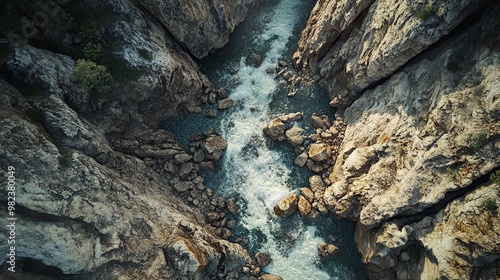 Aerial view of a river flowing through rocky cliffs, showcasing natural beauty.