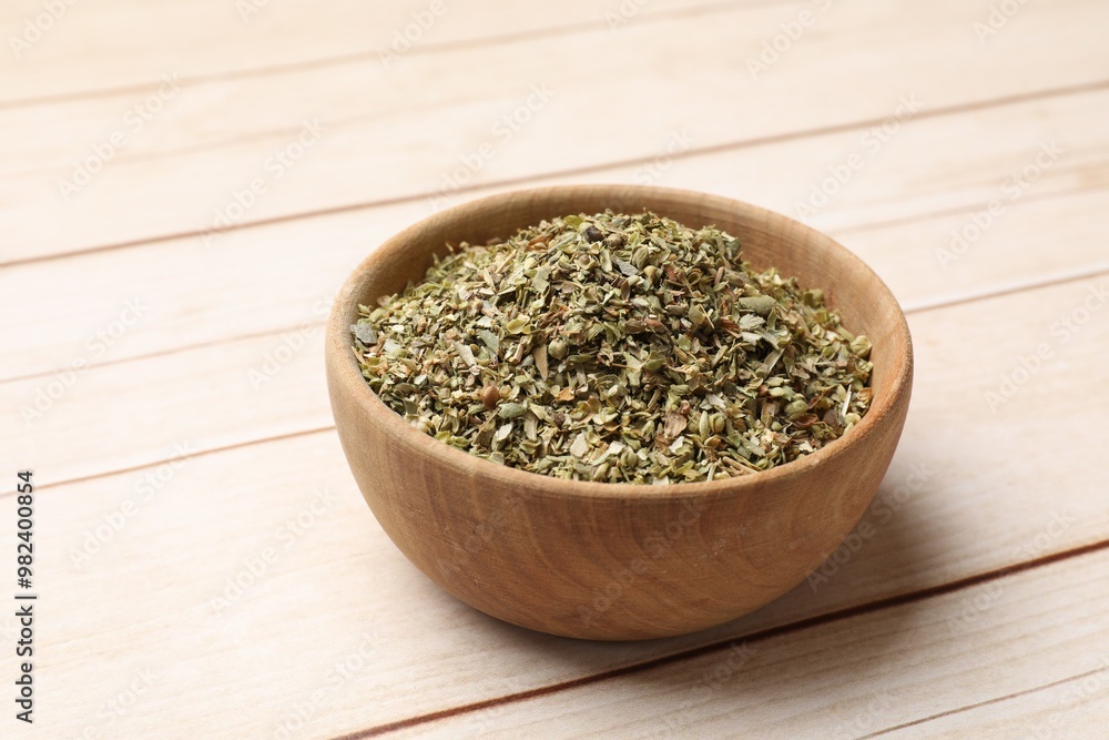 Dried oregano in bowl on wooden table, closeup Dried oregano in bowl on wooden table, closeup