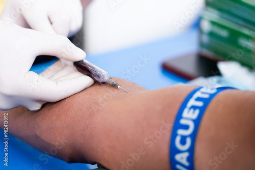 The doctor is taking a blood sample from the patient's arm for diagnosis photo