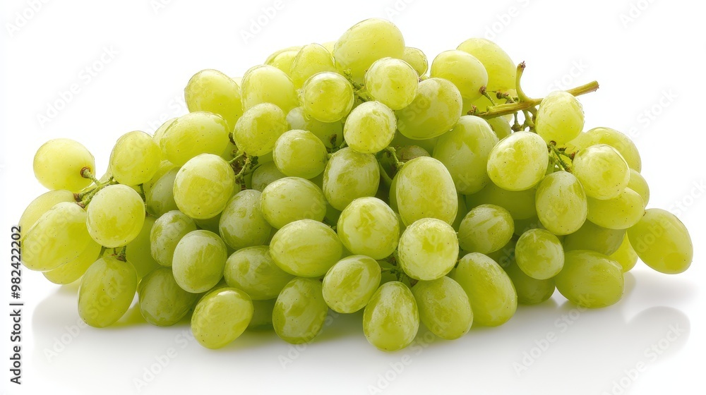 A cluster of green grapes with a few individual grapes scattered around, sitting on a clean white surface. The fruit is plump and glossy. A cluster of green grapes with a few individual grapes scattered around, sitting on a clean white surface. The fruit is plump and glossy.